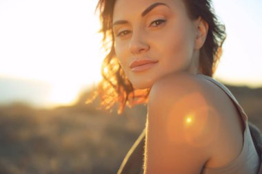 Güzel kadın. Doğada gün batımı ışığı olan genç bir kadının portresi..