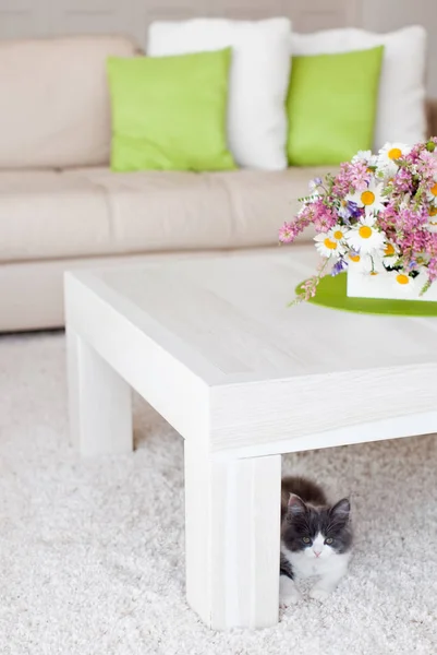 Interior with flowers, home comfort, a table with flowers and a cozy sofa next to it.