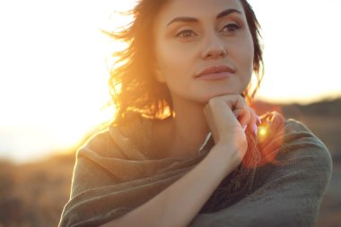 Güzel kadın. Doğada gün batımı ışığı olan genç bir kadının portresi..