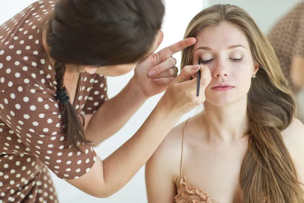 Maquiagem profissional. Maquiagem é feita para uma mulher bonita. — Fotografia de Stock