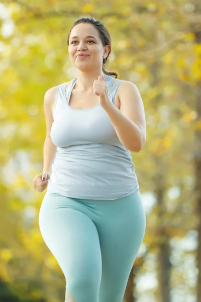 Mujer gorda y deportes. Hace ejercicio para bajar de peso al aire libre. — Foto de Stock