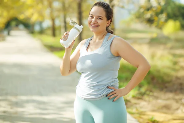 Mujer gorda y deportes. Hace ejercicio para bajar de peso al aire libre. — Foto de Stock