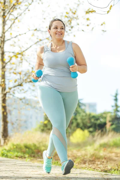 Şişman kadın koşuyor, kilo vermek için spor yapıyor, obezite problemi var..
