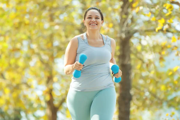 Şişman kadın koşuyor, kilo vermek için spor yapıyor, obezite problemi var..