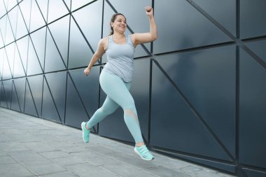 Şişman kadın koşuyor, kilo vermek için spor yapıyor, obezite problemi var..