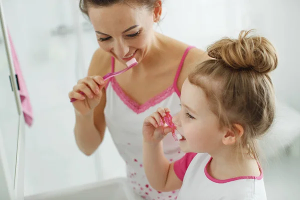 Мама з дитиною чистять зуби.. — стокове фото