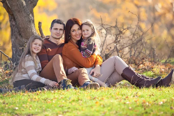 Осенью семья отдыхает на природе. Женщина с мужчиной весело играют с детьми. — стоковое фото
