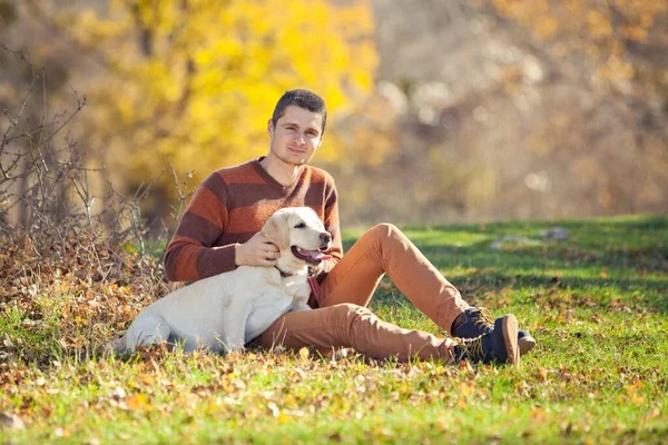 Hund und sein Besitzer, ein junger Mann, haben Spaß im Park - Konzepte der Freundschaft, Haustiere, Zweisamkeit. — Stockfoto