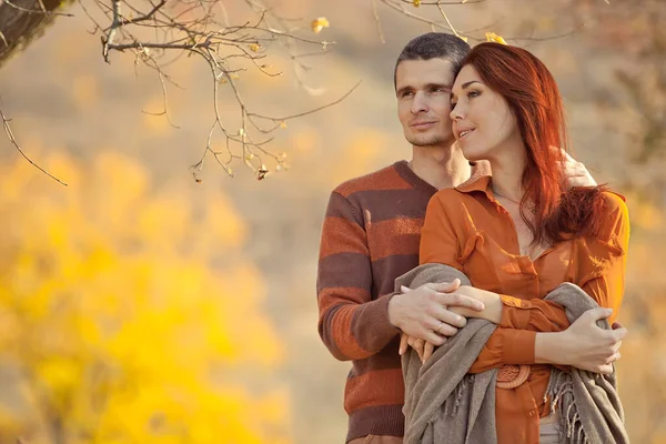 美しいカップルの男の愛の女性。秋の日に公園で抱き合って笑っている男と女の子. — ストック写真