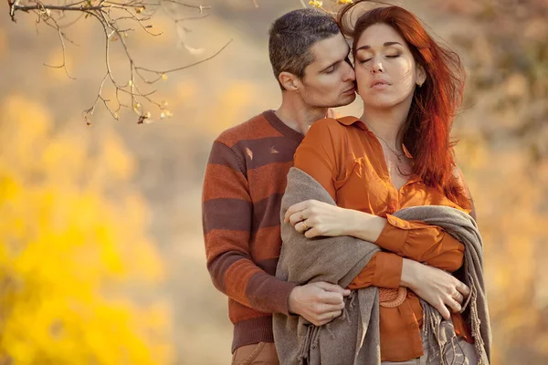 美しいカップルの男の愛の女性。秋の日に公園で抱き合って笑っている男と女の子. — ストック写真