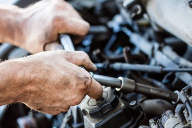 Otomobil tamircisi garajda çalışıyor. Araba servisi, onarım ve onarım. İngiliz anahtarı..