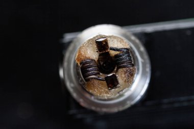 Vaping veya e-sigara sualtındaki e-sıvı, modern vape aygıt için sigarayı, makro fotoğraf seçici odak ile bobin ve pamuk çizgili Rebuildable damlama atomizer.