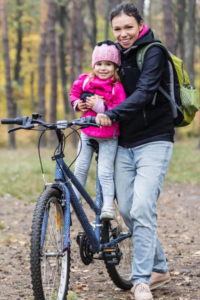 愉快的母亲和女儿骑自行车在秋季公园 — 图库照片