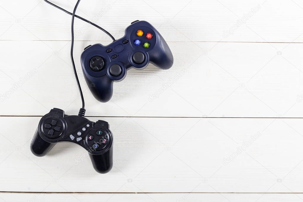 Retro computer gaming controllers placed on wooden background. Home video games time concept.