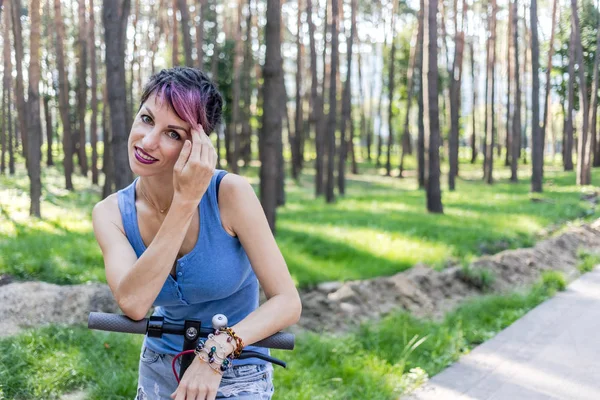 Coole attraktive Frau mit rosa Haaren, genießt das Reiten auf einem elektrischen — Stockfoto