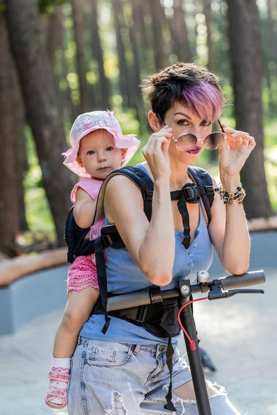 Coole aantrekkelijke vrouw geniet van het rijden op een elektrische scooter met haar — Stockfoto