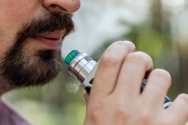 Adam sigara vape cihazı kullanarak.