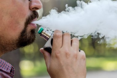 Adam sigara vape cihazı kullanarak.