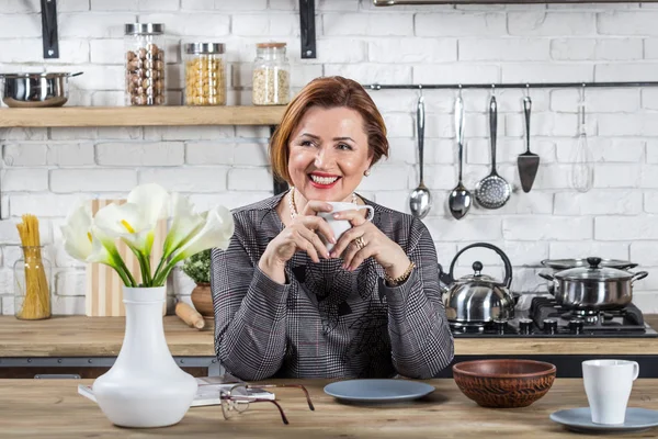 Senior zakenvrouw ontspannen in kantoor keuken. — Stockfoto