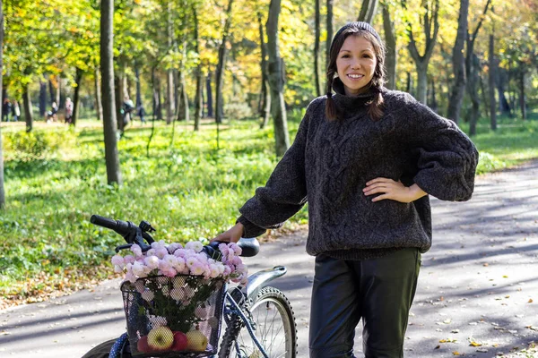 Gelukkig jonge vrouw met fiets ontspannen in het park. — Stockfoto