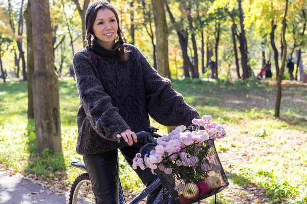 Gelukkig jonge vrouw met fiets ontspannen in het park. — Stockfoto