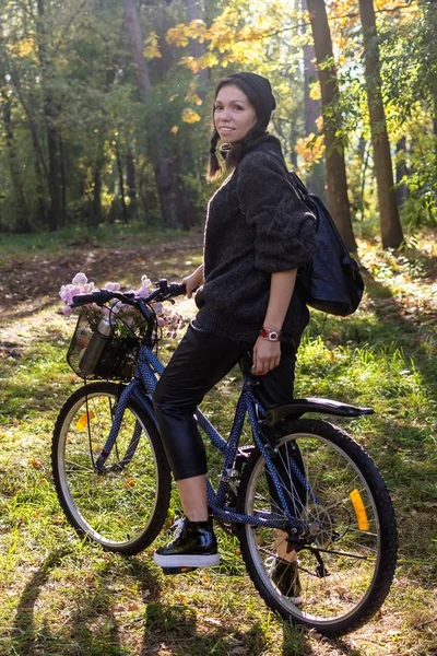 Gelukkig jonge vrouw met fiets ontspannen in het park. — Stockfoto