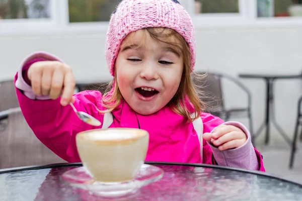Little girl fooling around with coffee. — Stock Photo, Image