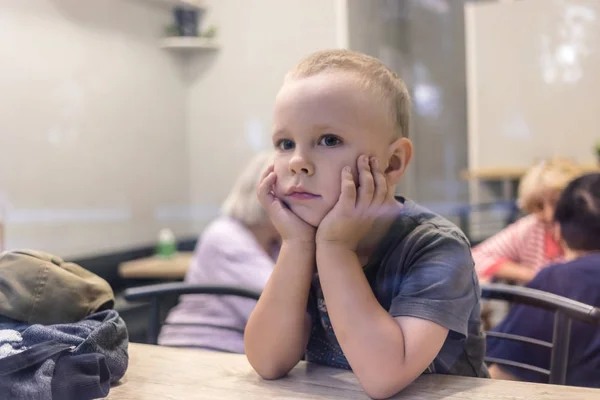 Pequeño niño sentado en una cafetería . —  Fotos de Stock