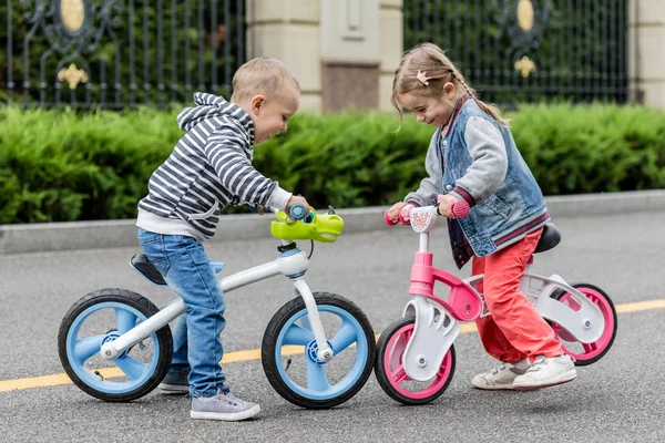 Happy Kids med cyklar ha kul på vägen på dagen tid. — Stockfoto