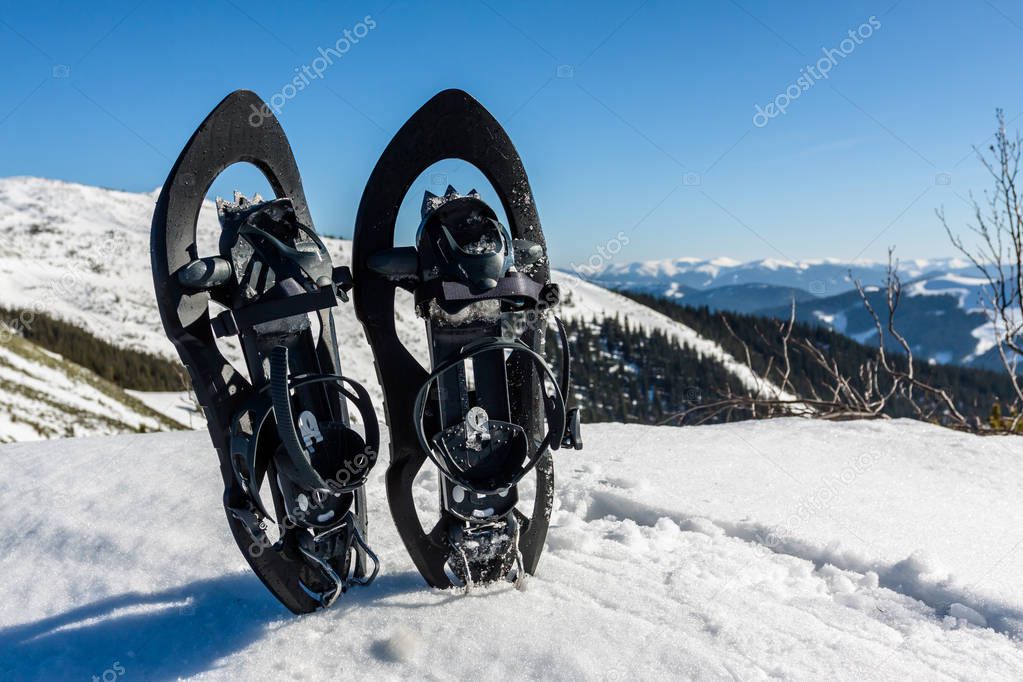 Snowshoes in snow at winter mountains
