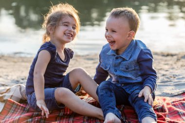 Mutlu çocuklar gülümseyerek ve sahilde etrafında oyalama.