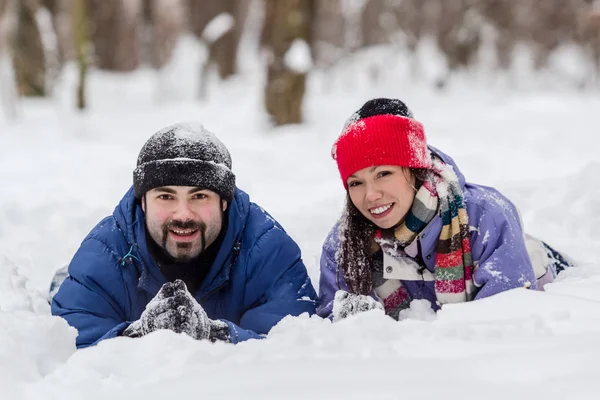 Pojke och flicka som har kul i snön på vintern — Stockfoto