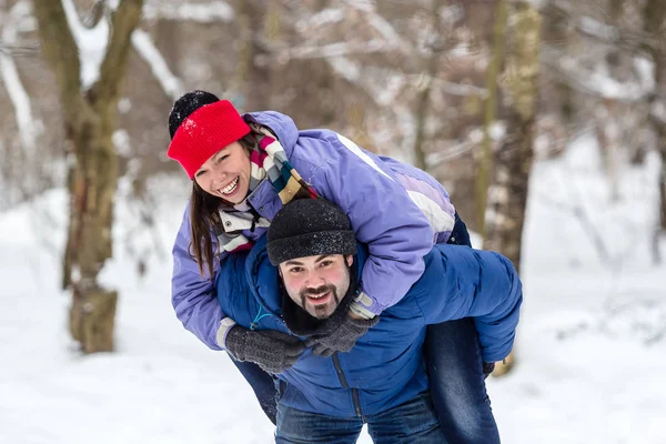 Chico y chica divirtiéndose en la nieve en invierno — Foto de Stock