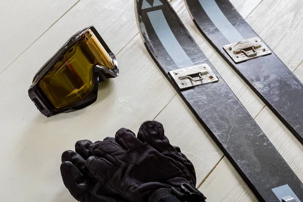 Režijní náklady na lyžařská příslušenství umístěná na rustikální bílé dřevěné t — Stock fotografie