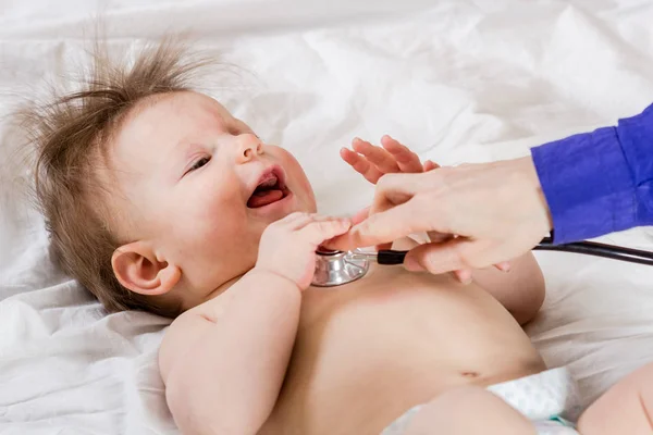 Lekarz sprawdza stan dziecka za pomocą stetoskop. Leczyć — Zdjęcie stockowe