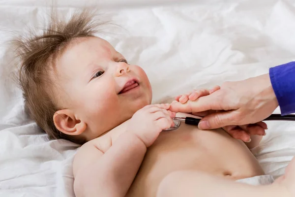 Der Arzt überprüft den Zustand des Kindes mit einem Stethoskop. Heilung — Stockfoto