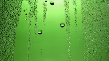 Yeşil cam üzerine yağmur damlaları yakın plan
