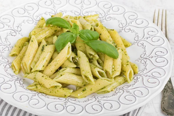 Penne rigate makarna fesleğen pesto ile plaka closeup.