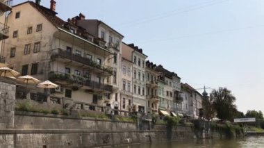Ljubljana, Slovenya - 29 Ağustos 2018: Eski tarihi, ortaçağ, binalar, açık havada kafeler, restoranlar ve Ljubljanica Nehri'nin kıyısında küçük dükkanlar.