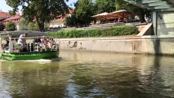卢布尔雅那 斯洛文尼亚 2018年8月29日 绿龙旅游船在 Ljubjanica 河下的屠夫桥 绿龙提供导河游 — 图库视频影像