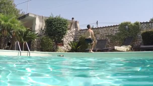スイミング プールでジャンプ白人男背中のスローモーション — ストック動画