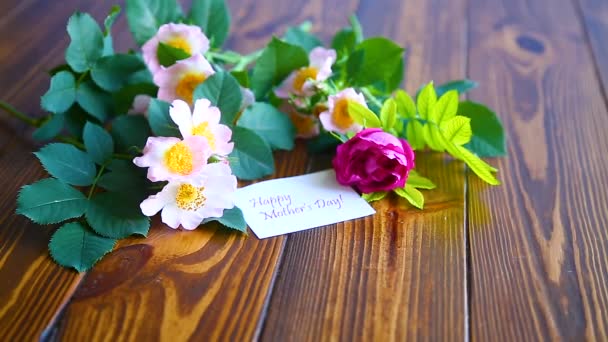 Hermosas rosas florecientes y una tarjeta de felicitación para la madre — Vídeos de Stock