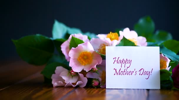 Hermosas rosas florecientes y una tarjeta de felicitación para la madre — Vídeo de stock
