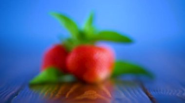 mavi bir arka plan üzerinde kırmızı olgun organik çilek