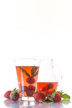 Olgun kırmızı çilek beyaz zemin üzerinde bir cam sürahi içinde tatlı komposto