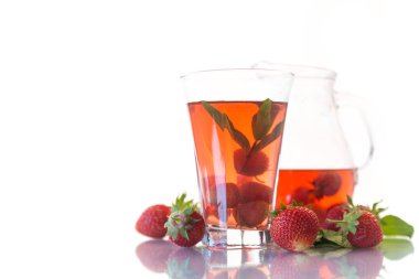 Olgun kırmızı çilek beyaz zemin üzerinde bir cam sürahi içinde tatlı komposto