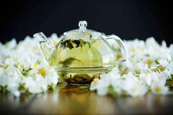 茶几上的玻璃茶壶里有茉莉花花的茶 — 图库照片