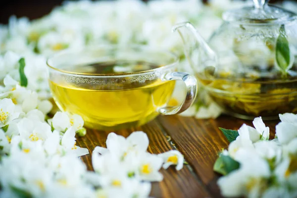 Tee Mit Jasminblüten Einer Glasteekanne Auf Einem Tisch — Stockfoto