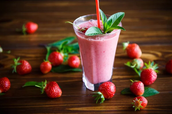 桌上的玻璃杯中的草莓鲜甜果汁 — 图库照片
