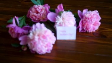 ahşap bir masa üzerinde çiçek açan peonies buket